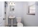 Clean and bright bathroom features a pedestal sink, toilet, and tiled shower at 5601 Andora St, Orlando, FL 32807