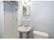 Clean and bright bathroom features a pedestal sink, toilet, and tiled shower at 5601 Andora St, Orlando, FL 32807