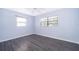 This bedroom offers gray vinyl floors, fresh light blue paint, a ceiling fan, and a window for natural light at 5601 Andora St, Orlando, FL 32807