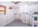 Utility room with water heater, gray painted floor, storage cabinet, and concrete block walls at 5601 Andora St, Orlando, FL 32807