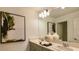 Bright bathroom featuring double sinks with gray cabinets, stylish decor, and a large mirror at 5657 Loggia Ln, Kissimmee, FL 34758