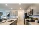 Bright kitchen featuring stainless steel appliances, a large island, and lots of cabinet space at 5657 Loggia Ln, Kissimmee, FL 34758