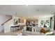 Bright living room featuring a sofa, stairs, gray cabinets, stainless appliances, and natural light at 5657 Loggia Ln, Kissimmee, FL 34758