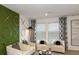 Cozy living room has three white armchairs, modern patterned curtains, and a cool accent wall at 5657 Loggia Ln, Kissimmee, FL 34758