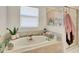 Bright bathroom features a soaking tub with a separate glass-enclosed shower at 6822 Habitat Dr, Harmony, FL 34773