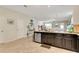 Modern kitchen island with sleek countertops and dark cabinetry, seamlessly flowing into the dining and living spaces at 6822 Habitat Dr, Harmony, FL 34773