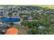 Aerial view of a community with a pond, baseball field, tennis court, a fountain, and a variety of homes and trees at 694 Tuscora Dr, Winter Springs, FL 32708
