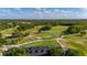 Breathtaking aerial of golf course with meticulously manicured green and clubhouse nestled within natural beauty at 694 Tuscora Dr, Winter Springs, FL 32708