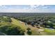 Serene aerial of rolling green fairways and sand traps set amid lush trees, showcasing prime golfing at 694 Tuscora Dr, Winter Springs, FL 32708