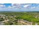 Expansive aerial view showcasing the neighborhood, lush greenery, and a glimpse of the water in the distance at 694 Tuscora Dr, Winter Springs, FL 32708