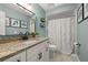 Bathroom featuring vanity with granite countertops, a large mirror and a shower behind a patterned curtain at 694 Tuscora Dr, Winter Springs, FL 32708