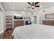 A spacious bedroom is complete with wood floors, a ceiling fan, a dresser, a TV, and comfortable seating at 694 Tuscora Dr, Winter Springs, FL 32708