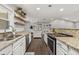 Efficient kitchen layout with white cabinets, granite counters, and stainless steel appliances at 694 Tuscora Dr, Winter Springs, FL 32708