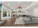 Spacious living room with hardwood floors, a stylish gray sectional, and sliding doors to the outdoors at 694 Tuscora Dr, Winter Springs, FL 32708