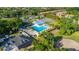 Aerial view of a large swimming pool with lounge chairs, palm trees, and well-maintained tennis courts in a great community at 694 Tuscora Dr, Winter Springs, FL 32708