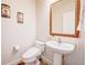 A half bathroom featuring a pedestal sink, decorative mirror, and tiled floor at 7348 Yoder St, Windermere, FL 34786