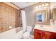 A full bathroom with tiled walls, a bathtub, and a vanity with modern fixtures at 7348 Yoder St, Windermere, FL 34786