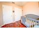 This Bedroom features a crib, hardwood floors, and multiple closets for storage at 7348 Yoder St, Windermere, FL 34786
