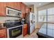 This kitchen features stainless steel appliances, wood cabinetry, and granite countertops at 7348 Yoder St, Windermere, FL 34786