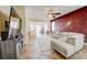 Bright living room with tile floors, a large sofa, decorative wall art, and access to the dining and kitchen at 7348 Yoder St, Windermere, FL 34786