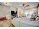 Open-concept living room with tile flooring, neutral paint, ceiling fan and view into the dining and kitchen areas at 7348 Yoder St, Windermere, FL 34786