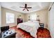 Main bedroom features a tray ceiling, a large bed, and hardwood floors at 7348 Yoder St, Windermere, FL 34786