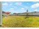 A large, grassy backyard with a privacy fence and an outdoor umbrella with seating at 740 Simone Ct, Haines City, FL 33844