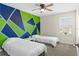 Well-lit bedroom with two twin beds and geometric accent wall at 740 Simone Ct, Haines City, FL 33844