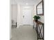 Bright and airy entryway showcasing neutral tile flooring and decorative table with mirror at 740 Simone Ct, Haines City, FL 33844