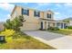 Attractive two-story home with blue shutters, a two-car garage, and a driveway surrounded by green grass at 740 Simone Ct, Haines City, FL 33844