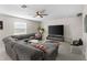Cozy living room with a large sectional sofa, ceiling fan, and entertainment center at 740 Simone Ct, Haines City, FL 33844