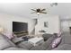 Comfortable living room area with a large sectional sofa, ceiling fan, and stairs to the second floor at 740 Simone Ct, Haines City, FL 33844