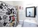 Bathroom with a shower/tub combo, mickey-themed shower curtain, and white vanity at 7505 Pellham Way, Kissimmee, FL 34747