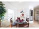Charming dining area with a glass table set for four, adjacent to the living area and kitchen at 7505 Pellham Way, Kissimmee, FL 34747
