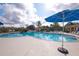 Community pool featuring comfortable seating, umbrellas, palm trees, and a sunny Florida day at 7505 Pellham Way, Kissimmee, FL 34747
