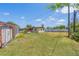 A sprawling backyard, with a partial view of neighboring buildings and a chainlink fence at 7700 Grevillea Dr, Orlando, FL 32822