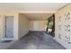 Covered carport featuring white doors, geometric shapes in the wall, and a view of trees at 7700 Grevillea Dr, Orlando, FL 32822
