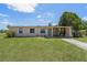 Charming single-story home featuring a covered carport and a well-maintained front lawn at 7700 Grevillea Dr, Orlando, FL 32822