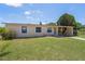 Cozy single-story home with a covered carport and a neatly manicured lawn at 7700 Grevillea Dr, Orlando, FL 32822
