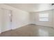 Simple living area with white walls, terrazzo flooring, and a window at 7700 Grevillea Dr, Orlando, FL 32822