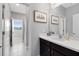 Well-lit bathroom with decorative art, a vanity with sink, and a view to the adjacent toilet and shower area at 8263 Bellow St, Orlando, FL 32827