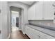 Hallway with a granite countertop and cabinetry leading to the laundry room at 8263 Bellow St, Orlando, FL 32827