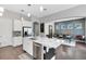 Spacious kitchen featuring a center island with seating, white cabinetry, stainless steel appliances and open dining space at 8263 Bellow St, Orlando, FL 32827
