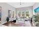 Bright living room with hardwood floors, large windows and a white sofa with neutral accents at 8263 Bellow St, Orlando, FL 32827