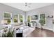 Bright living room with hardwood floors, large windows, ceiling fan, white sofa and decor at 8263 Bellow St, Orlando, FL 32827