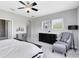 Bright main bedroom with neutral paint, large windows, chair, side table and dresser at 8263 Bellow St, Orlando, FL 32827