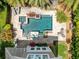 Aerial view of a private pool, spa, and patio area with lush landscaping and comfortable seating in backyard at 8263 Bellow St, Orlando, FL 32827