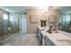 This bright bathroom features a glass-enclosed shower, double sinks, and quartz countertops at 857 Junonia Blvd, New Smyrna Beach, FL 32168