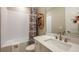 This bathroom features a shower-tub combo with a white tile backsplash and decorative shelf at 857 Junonia Blvd, New Smyrna Beach, FL 32168