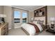 Cozy bedroom features two large windows with views of the surrounding water and trees at 857 Junonia Blvd, New Smyrna Beach, FL 32168